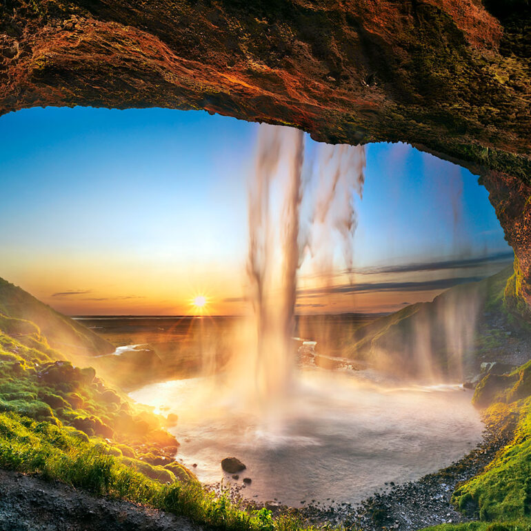 Waterfall from inside a cave at sunset in Iceland.