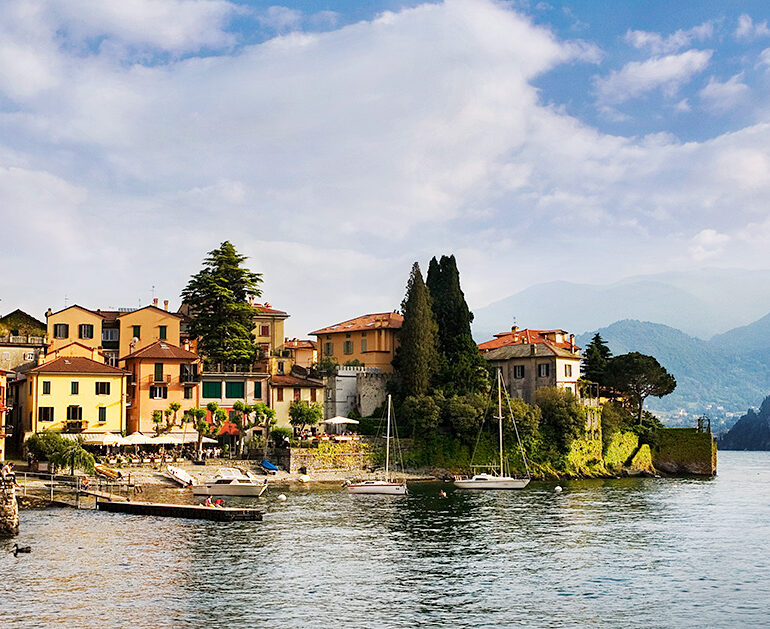 Single sailboat in a harbor of painted buildings.