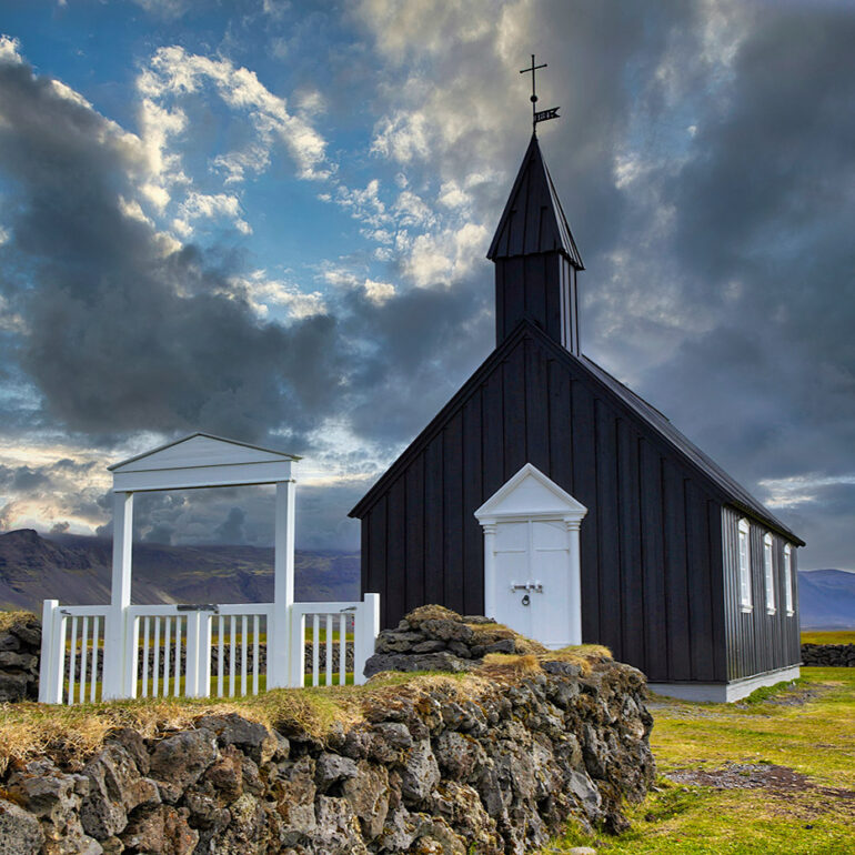 Black church with dramatic clouds.