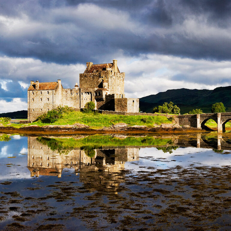 Castle on an island with a dramatic backdrop.