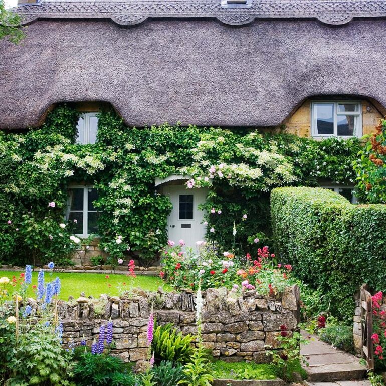 thatched roof cottage with flowers.