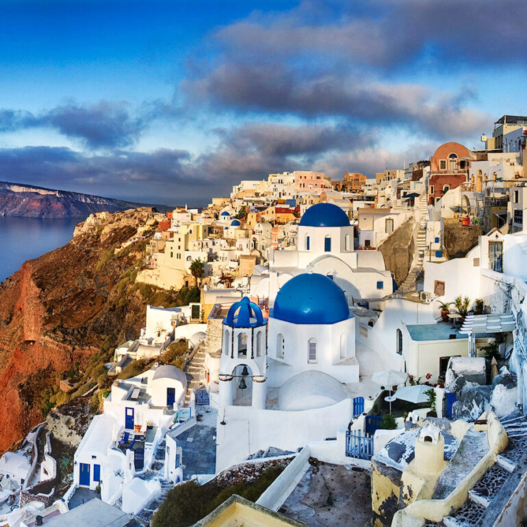The first light of the day bathes the blue domes of Santorini.