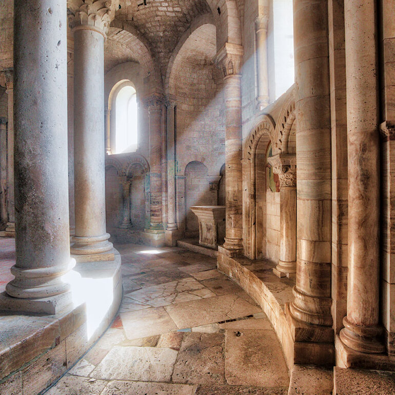 Shaft of light breacking through a window in an old church.