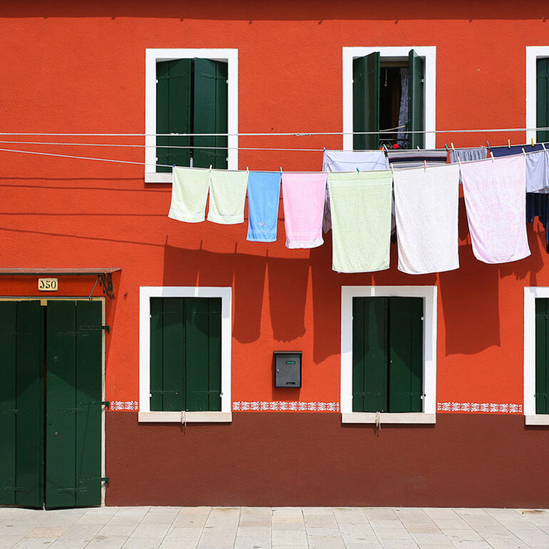Clothes hung out to dry against a brightly colored house.