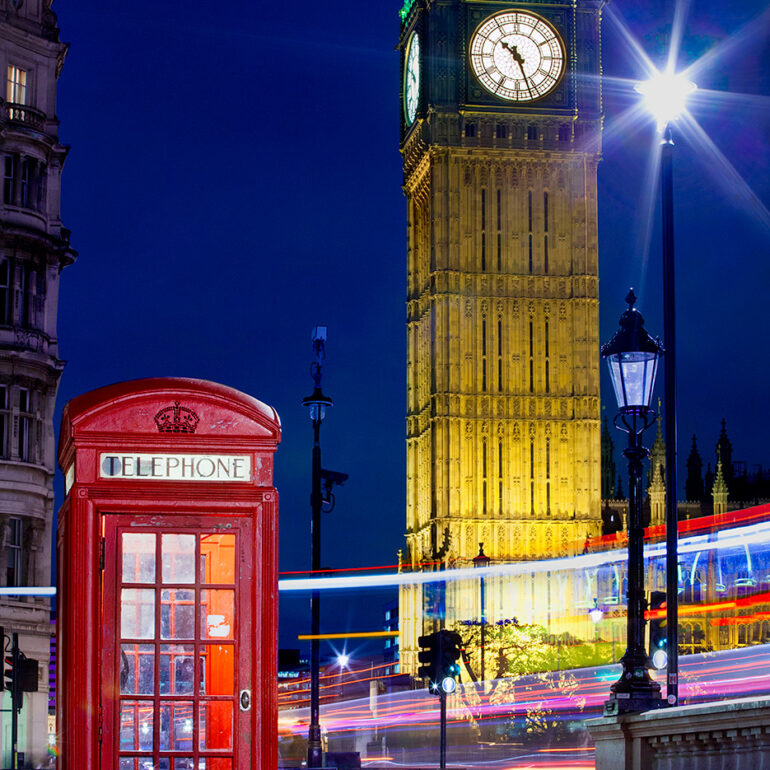 Big Ben at night with phone booth in front.