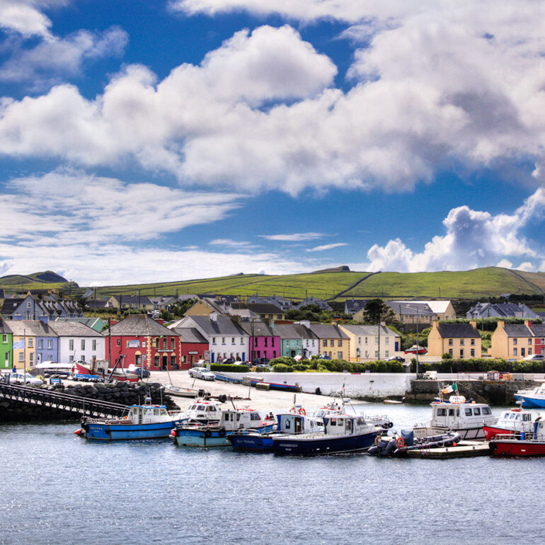 Harbor with boats surrounded by brightly painted houses.