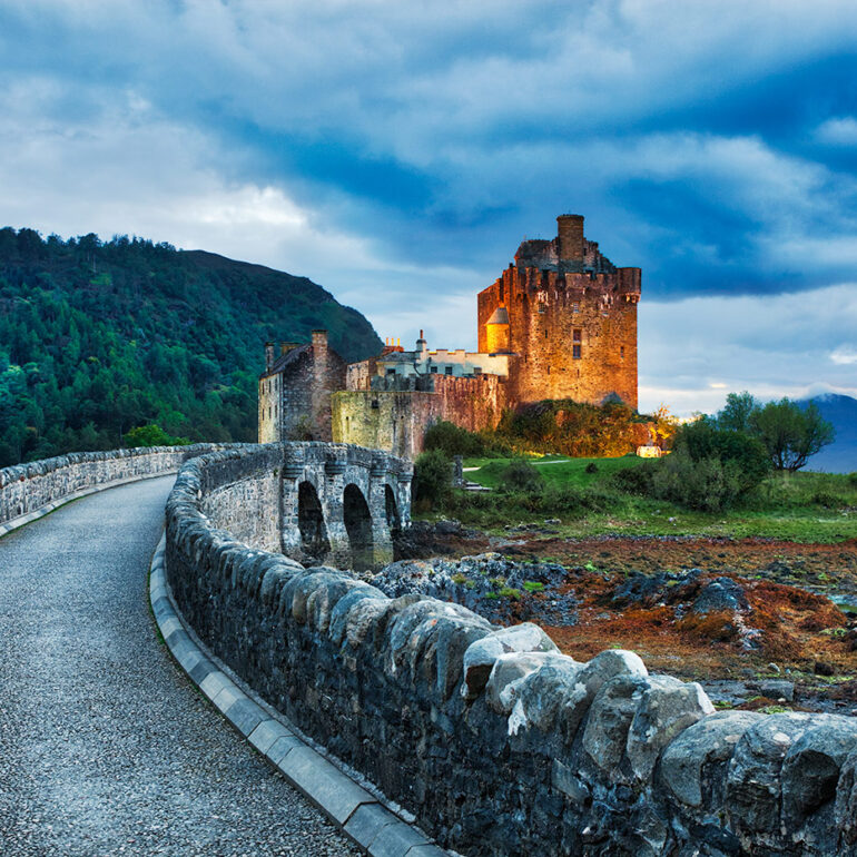 Bridge leading to a castle at dusk.