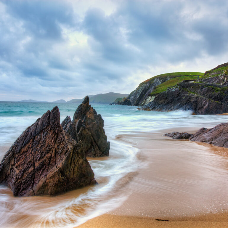 Rocks jutting out of the water along the beach.